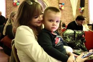 Chłopczyk siedzący na kolanach kobiety pozuje do zdjęcia