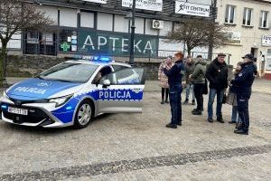 Małe dziecko siedzi za kierownicą auta policyjnego