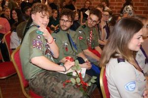 Trzej harcerze siedzą wśród publiczności