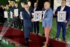 Przewodniczący Rady Miejskiej wręcza dyplom lauretowi