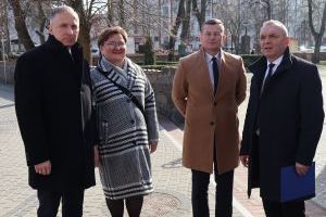 Burmistrz w towarzystwie trojga dyrektorów szkół pozują do zdjęcia