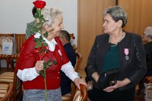 Jubilatka z różą pozuje do zdjęcia