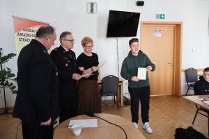 Nagrodzony uczeń pozuje do zdjęcia