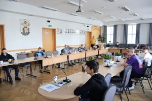 uczestnicy konkursu siedzą przy stołach konferencyjnych