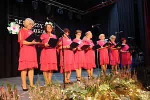 grupa seniorek na scenie ze śpiewnikami