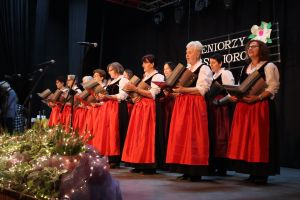 Grupa seniorek śpiewająca na scenie