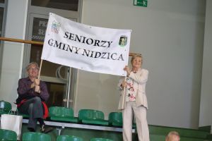 Seniorzy trzymają transparent