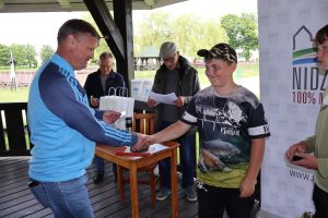 Uczestnik zawodów odbiera kartę wędkarskie