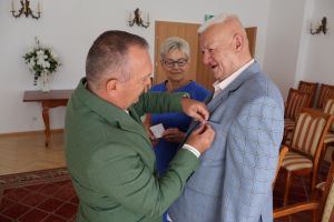 Jacek Kosmala - Burmistrz Nidzicy przypinający medal Jubilatowi