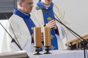 Księża stoją przed ołtarzem