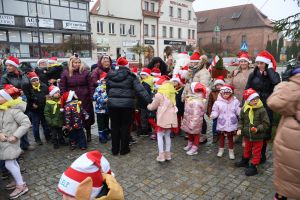 Dzeci z opiekunami czekają na odpalenie choinki