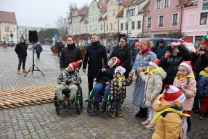 Dzieci z opiekunami czekaja na odpalenie choinki