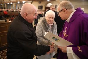 Ksiądz węcza dyplom jubilatom