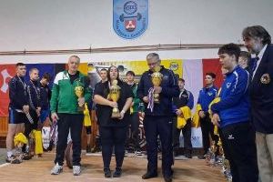 Trenerzy zespołów stoją z pucharami