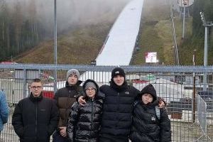 Sztangiści pozują do zdjęcia na tle skoczni narciarskiej