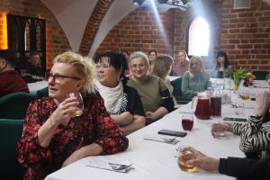 Uśmiechnięte kobiety siedzą przy stołach