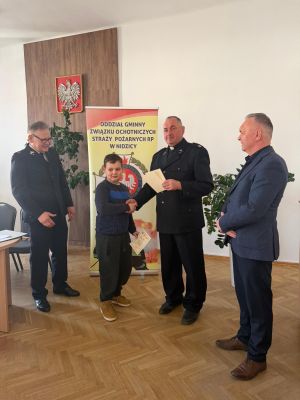 Organizator wręcza dyplom laureatowi