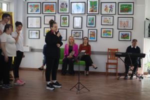 Kobieta zapowiada występy wychowanków ośrodka