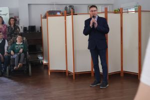 Mężczyzna stoi z mikrofonem na scenie