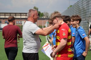 Mężczyzna wiesza medal na szyi zawodnika